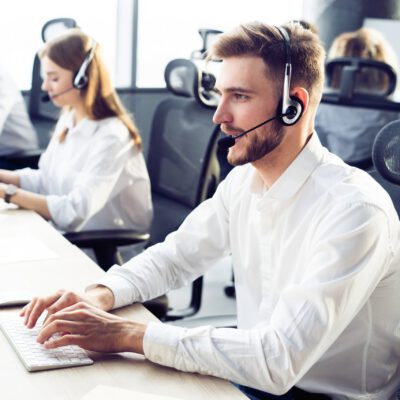 Happy young male customer support executive working in office